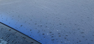 Before and after removing water spots from car paint
