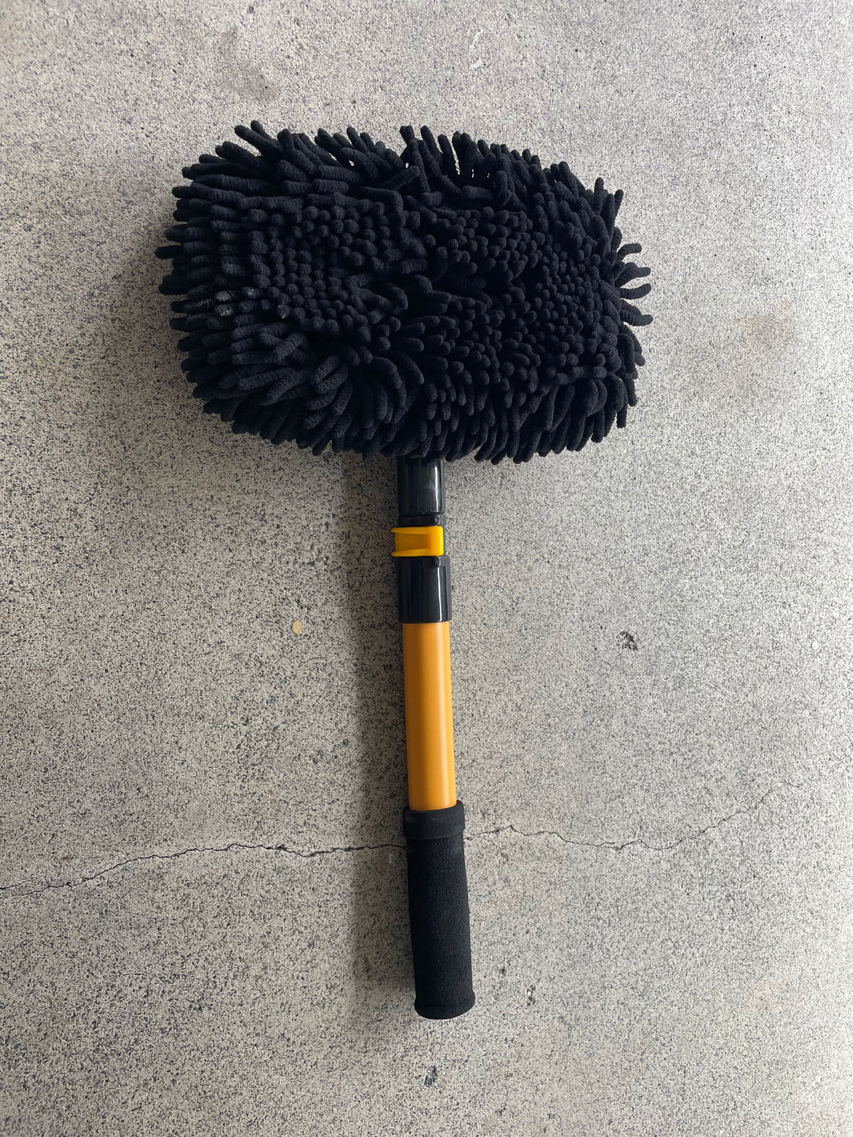 Underside of the car wash mop showing the thick black chenille wash surface