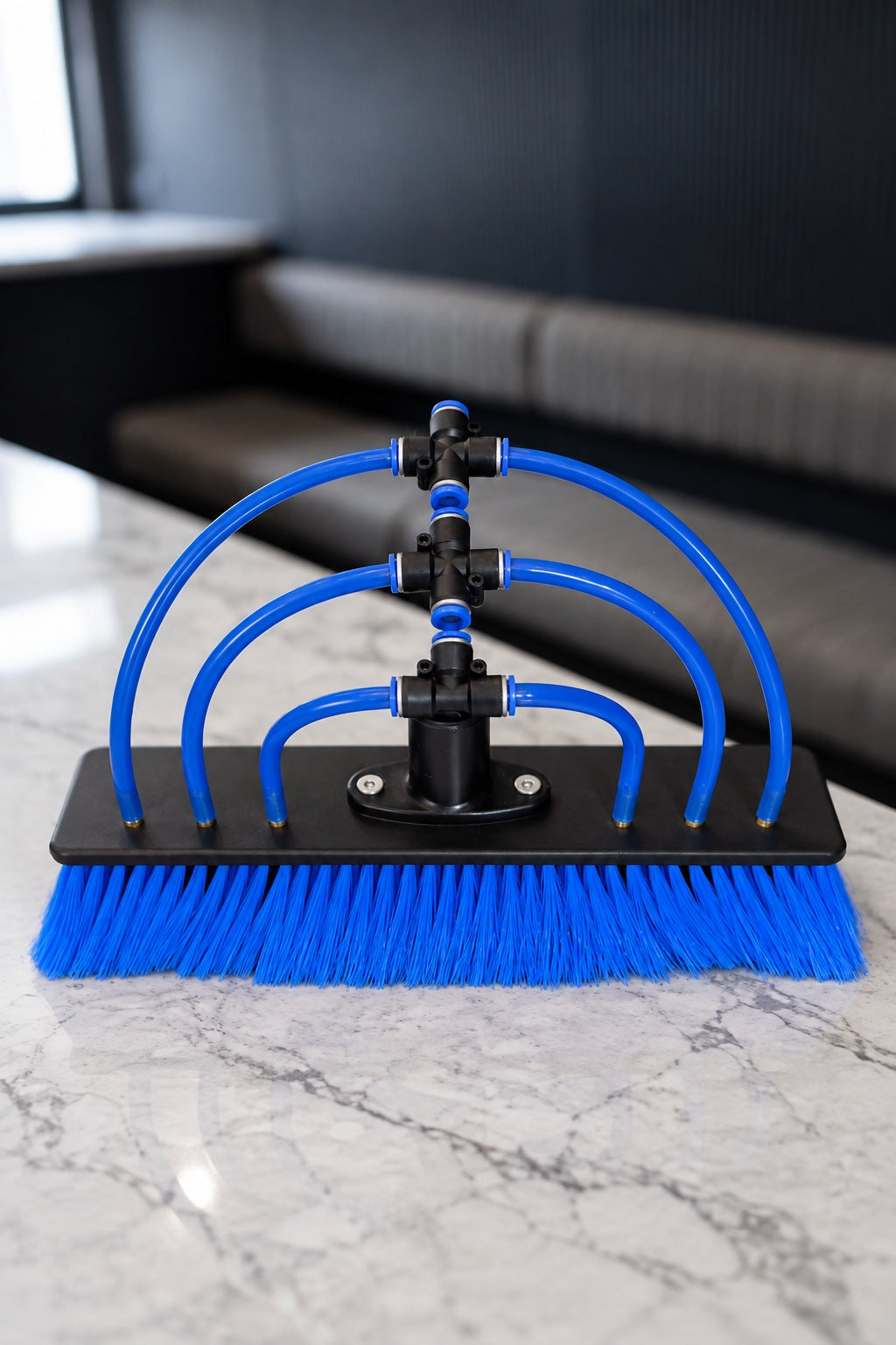 Blue nylon water fed pole brush with 6 jets and blue push fit tubes on a marble benchtop