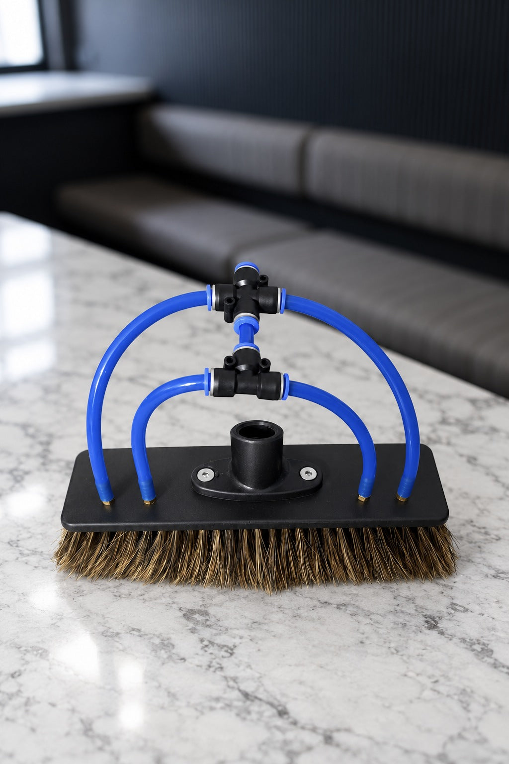 Top of the boar's hair water fed pole brush showing the threaded socket, blue tubes and fittings