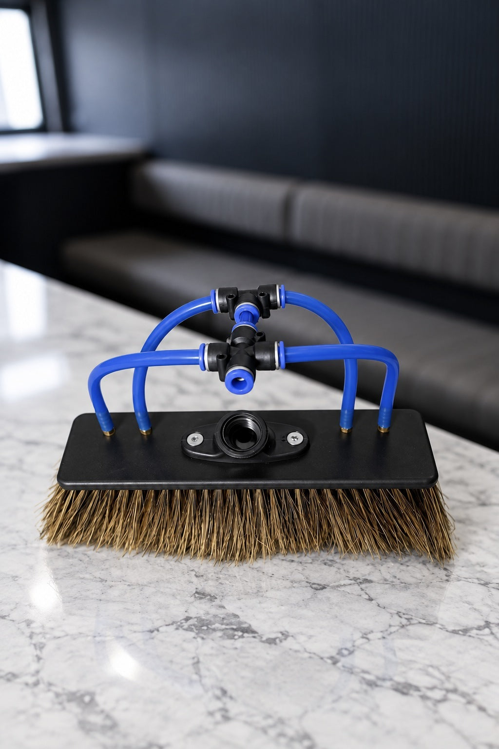 Boar's hair water fed pole brush with 4 jets and blue push fit tubes on a marble benchtop